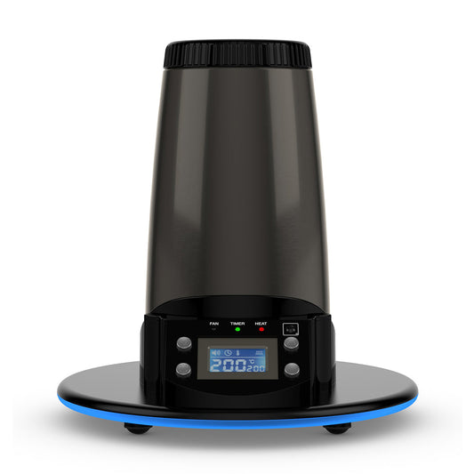 A crisp, front-facing studio product shot showcasing the Arizer Extreme Q Desktop Vaporizer standing upright. The shot highlights the sleek midnight-chrome cylindrical body, the bright blue illuminated digital LCD screen displaying temperature controls on the front panel, and the open heating chamber opening at the top peak on a clean background.