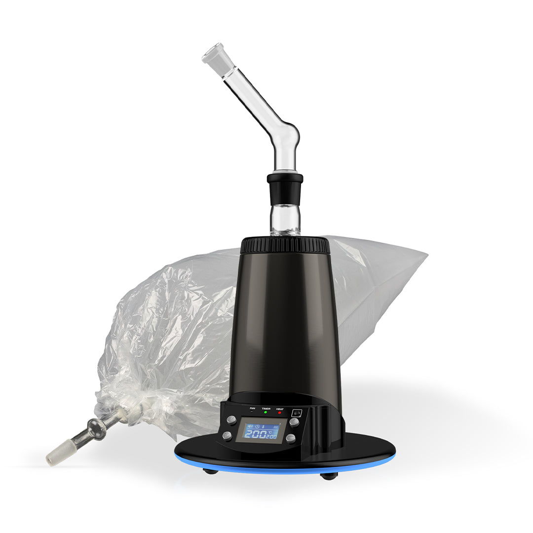 A detailed studio product shot of the Arizer Extreme Q Desktop Vaporizer configured with its forced-air balloon attachment setup. The clear glass balloon connector is docked vertically inside the top heating port of the midnight-chrome dome device, with a clear, elongated plastic vapor collection bag attached above it highlighting its clear glass mouthpiece tip.