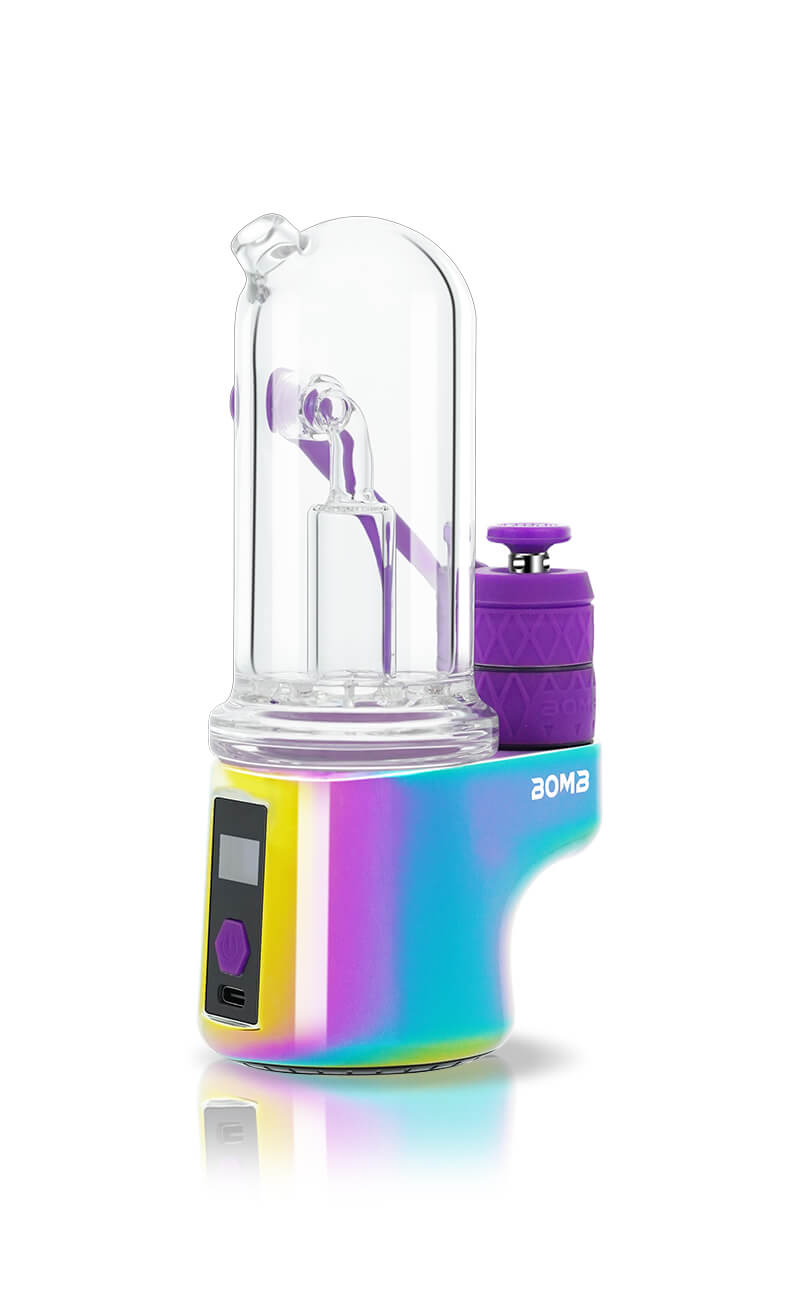 An angled rear view of the Rainbow Bomb Erig Aerix, focusing on the user interface. The image shows the integrated digital display, the central control button, and the USB-C charging port at the base of the multi-colored chassis.