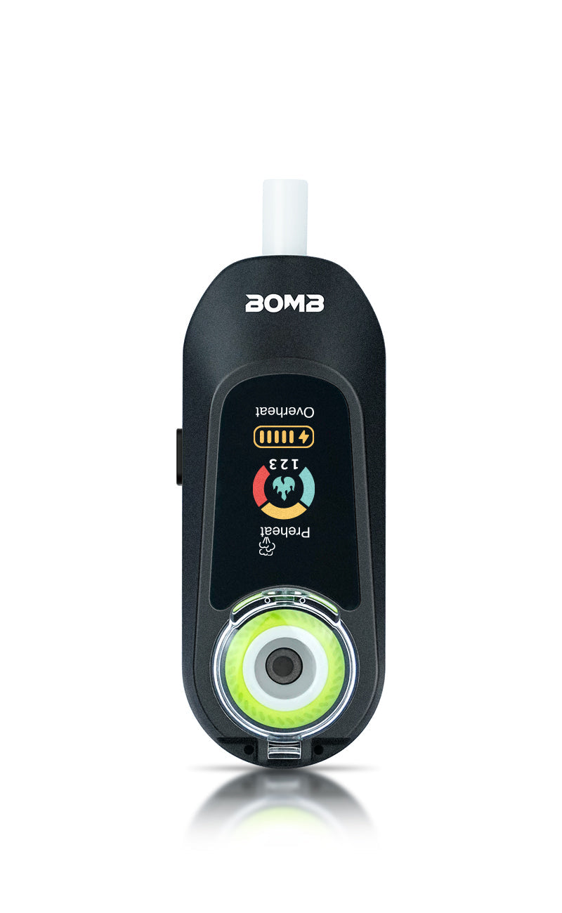 A direct front view of the  Bomb x VapX Magic Bean vaporizer, highlighting the recessed, high-purity ceramic coil/bowl and the vibrant digital display screen. This shot captures the textured, modern design of the Onyx Black pod.