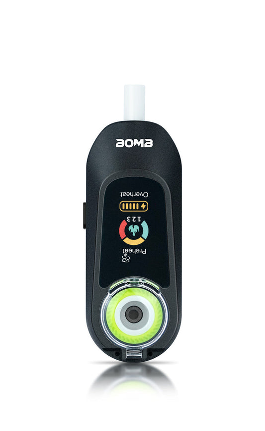 A direct front view of the  Bomb x VapX Magic Bean vaporizer, highlighting the recessed, high-purity ceramic coil/bowl and the vibrant digital display screen. This shot captures the textured, modern design of the Onyx Black pod.