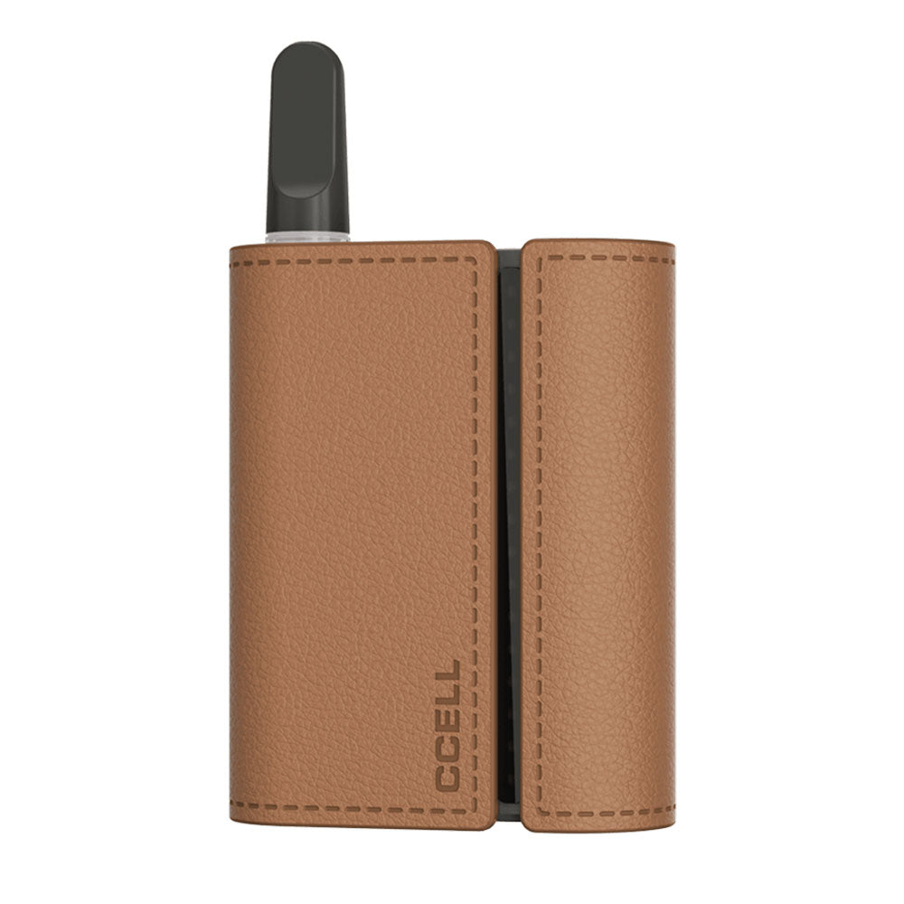 A front-facing studio shot of the CCELL Fino mini battery in Cocoa. The ultra-compact, rectangular dark brown vape unit is shown detached from its dock with a clear glass 510-thread oil cartridge installed in the top port, showcasing its minimal footprint.