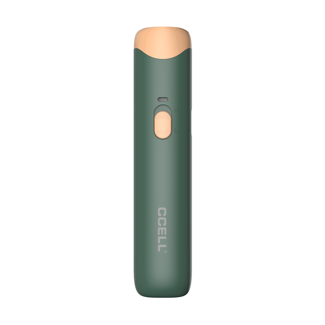 A front-facing studio shot of the CCELL Go Stik 510 Battery in Sunrise Pine. This sophisticated colorway features a deep forest green matte body accented by a warm, copper-colored mouthpiece and voltage slider. The vertical CCELL branding is visible at the bottom, highlighting the device's sleek, anti-roll oval design.