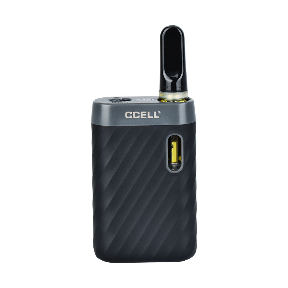 A front-facing studio shot of the CCELL Sandwave in Midnight Black with a 510-thread oil cartridge installed. The cartridge sits securely within the recessed magnetic drop-in port, exposing only the top glass section and clear mouthpiece above the device's signature wavy, textured frame.