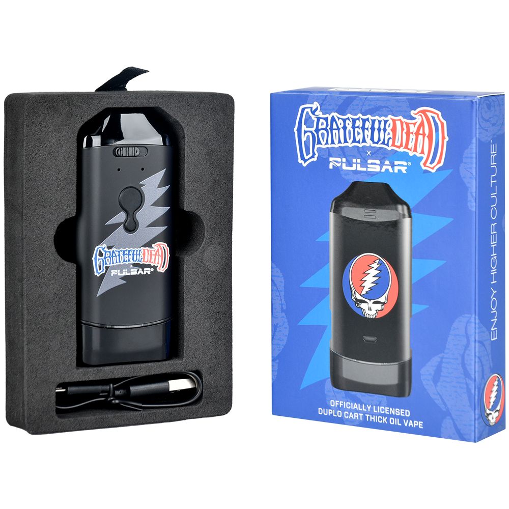 A clean studio presentation displaying the Grateful Dead x Pulsar DuploCart retail box alongside an open packaging layout. The unboxed view demonstrates how the custom-branded dual battery mod, the magnetic adapter rings, and the micro-USB charging cable are safely nested in precision foam cutouts for premium transit protection.