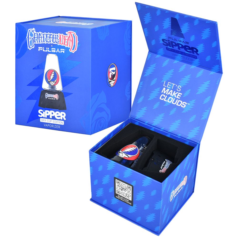 A clean studio presentation displaying the Grateful Dead x Pulsar Sipper retail box alongside an open packaging layout. The unboxed view demonstrates how the main 1500mAh base station, the custom Steal Your Face dry cup glass, the dabbing tool, and the charging accessories are securely nestled in custom-cut foam inserts for premium transit protection.