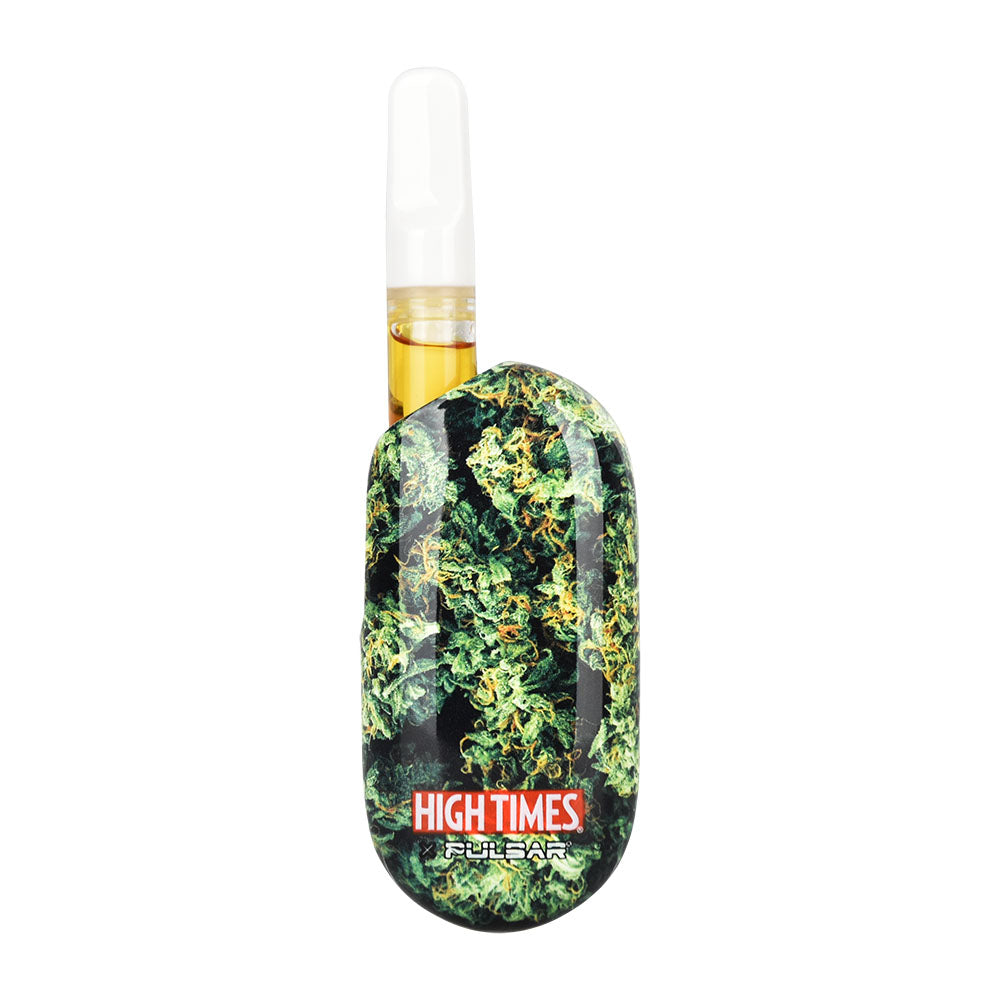A clean front-facing product shot of the High Times x Pulsar Obi in the High Times Flower design. The compact pocket battery features a vibrant graphic wrap of stylized cannabis fan leaves over a clean background, shown standing upright with a clear glass 510-threaded oil cartridge installed in its magnetic chamber.