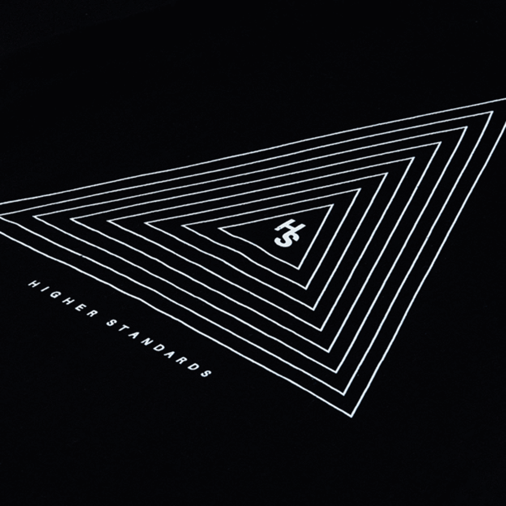 Close-up of the white concentric triangle graphic on the black Higher Standards T-shirt.