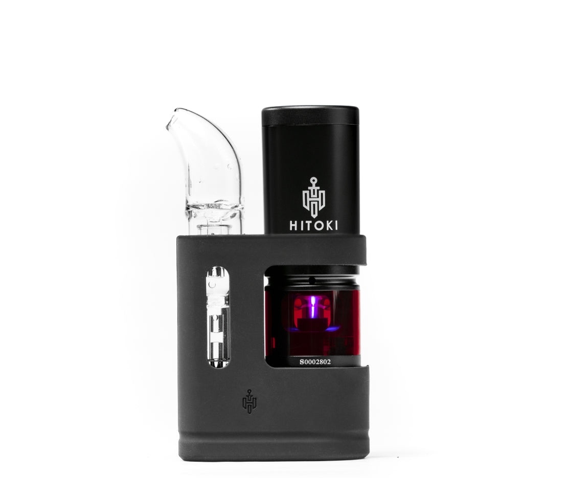 A side-facing view of the Hitoki Saber Portable Kit Device in a sleek matte black finish. The image showcases the modern, ergonomic design, the central power button, and the high-tech aesthetic of the laser combustion system.