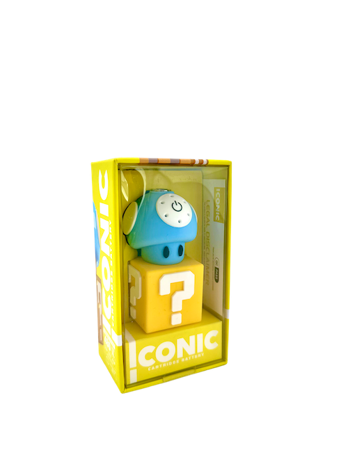 A clean front-facing product shot of the Iconic Mushroom Cartridge Battery in Blue presented in its retail packaging. The unit showcases a bright, glossy blue cap adorned with bold white spots resting over the white lower body, neatly displayed inside its custom-fit window box.