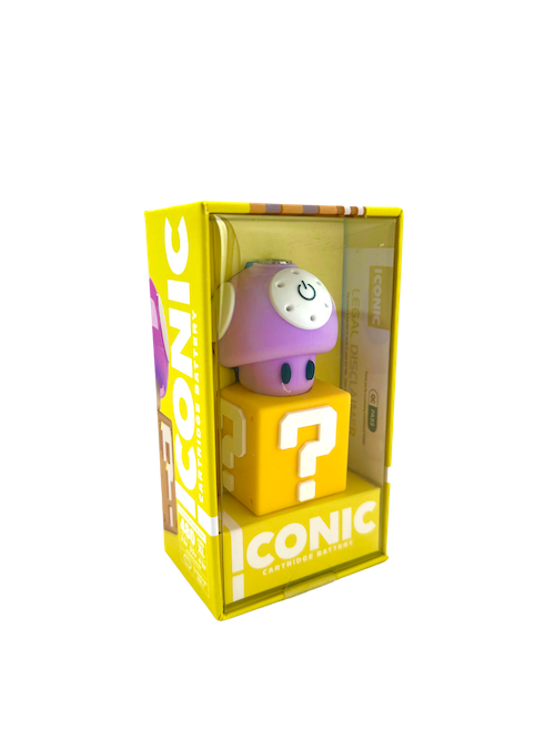 A clean, front-facing studio product shot of the Iconic Mushroom Battery in Purple displayed inside its official retail box. The device features a deep, glossy purple cap with classic white spots sitting on top of a clean white stem base, safely enclosed inside custom window packaging.