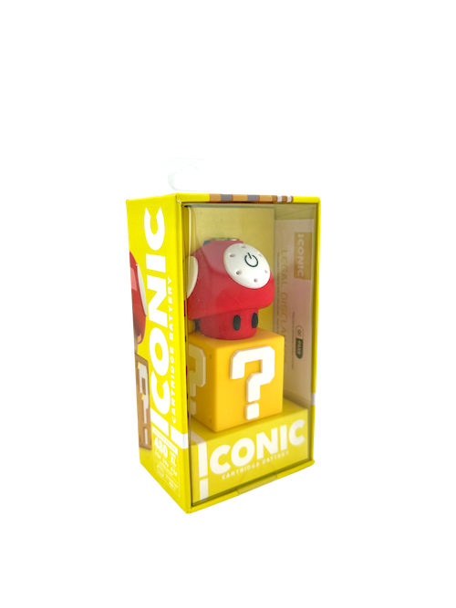 A crisp, front-facing studio product shot of the Iconic Mushroom Battery in Red displayed inside its official retail box. The device features a vibrant glossy red cap with iconic white spots sitting on top of a clean white stem base, securely nestled inside minimalist clear-window cardboard packaging.