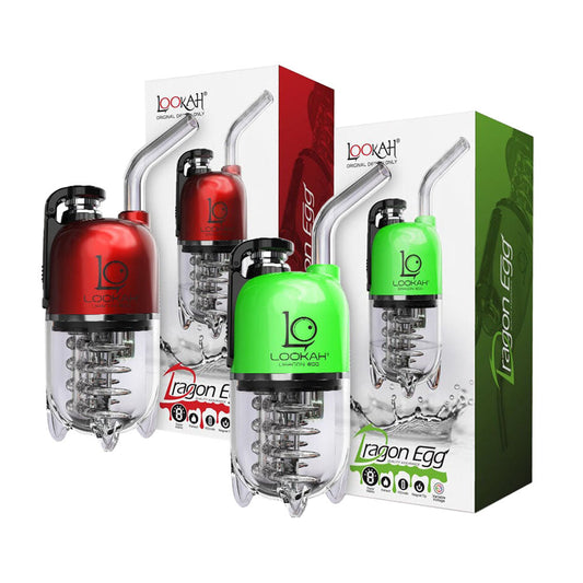 A studio product shot showcasing two LOOKAH Dragon Egg Electric Dab Rigs in Red and Green, each standing alongside its official retail box. The shot highlights the metallic top housings, curved glass straw mouthpieces, clear lower water chambers with internal ribcage percolators, and colorful box branding.