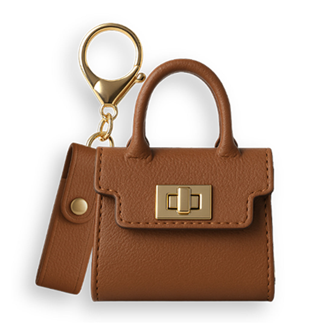 Side profile of a closed mini brown pebbled leather purse 510 vape battery case, showcasing the texture, handle, and gold keychain hardware.
