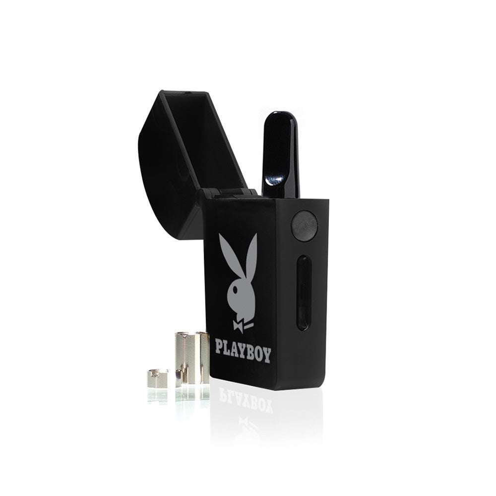 A crisp product breakdown shot featuring the Playboy x RYOT VERB 510 vape battery in the Bunny Head pattern with its top lid open. An oil cartridge is shown threaded into the internal magnetic bay, with the two gold-plated magnetic connector rings positioned right next to the device to showcase the full unboxed kit components.