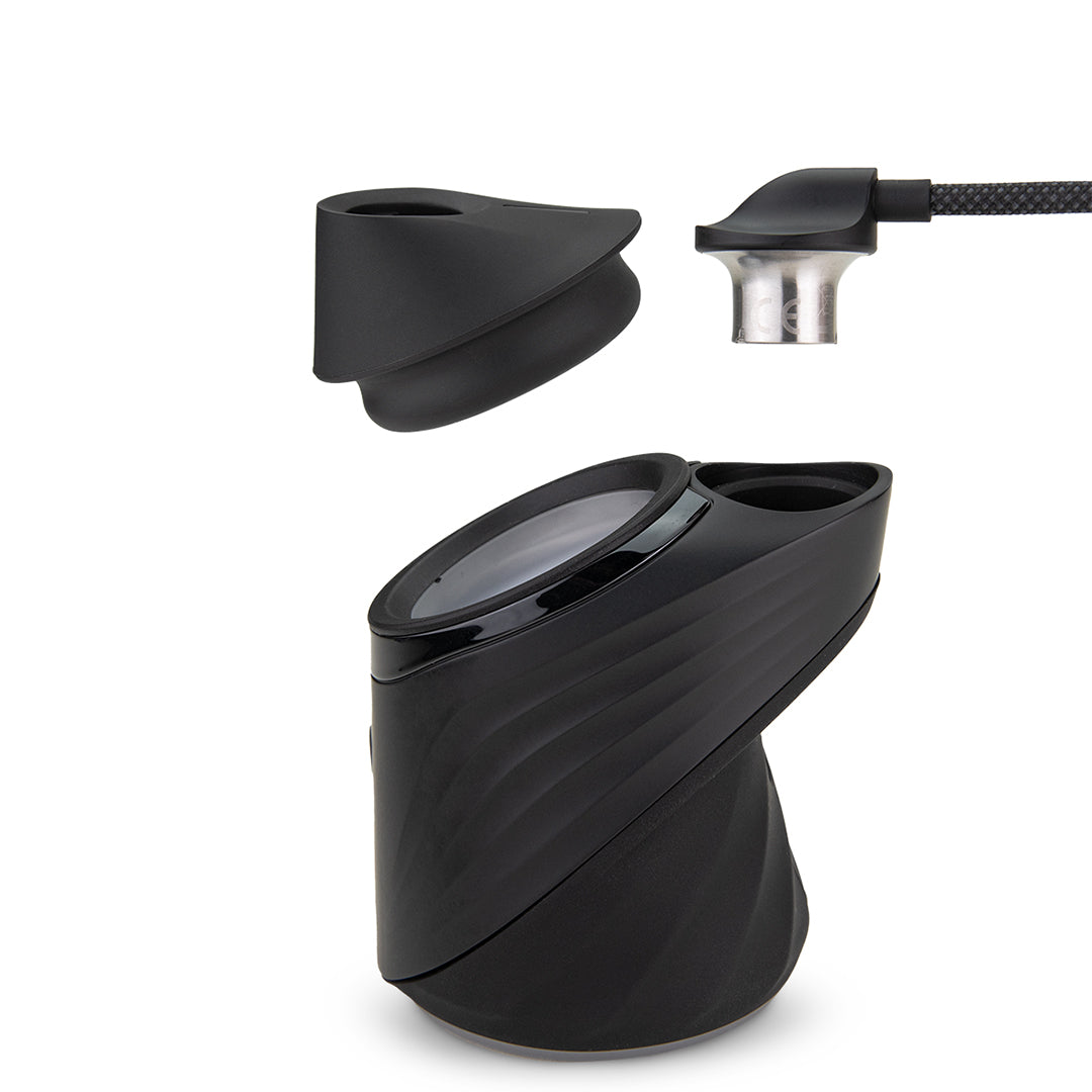 A detailed studio product shot showing the Puffco Peak Pro Link adapter components hovering above the Peak Pro power base. The photo illustrates the uninstalled rubber base adapter module hovering over the top chamber opening, alongside the link tether connector hovering directly above the connection port.