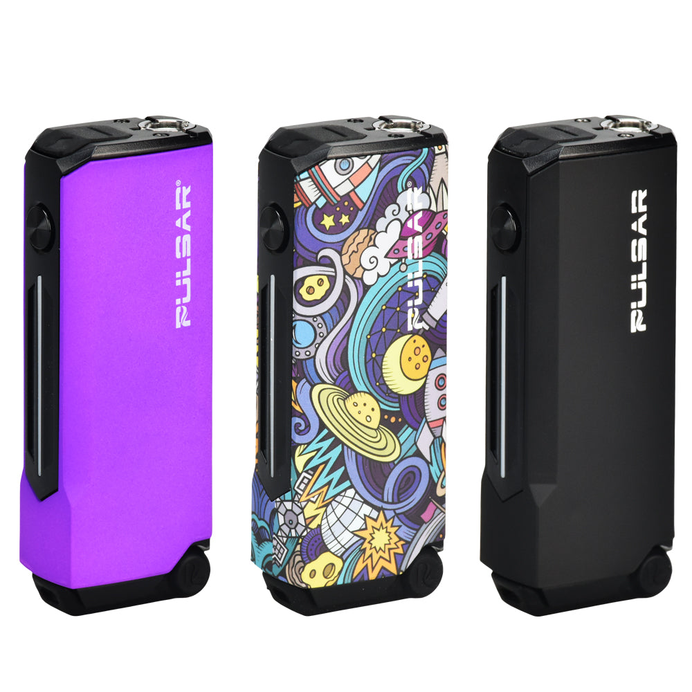 A studio display of three Pulsar 510 Dunk 2-In-1 Vaporizers standing side-by-side. From left to right, the finishes shown are Thermo Purple (a dynamic color-changing gradient), Space Junk (a stylized, psychedelic space-themed graphic pattern), and solid matte Black, highlighting the device's compact, button-operated rectangular frame.