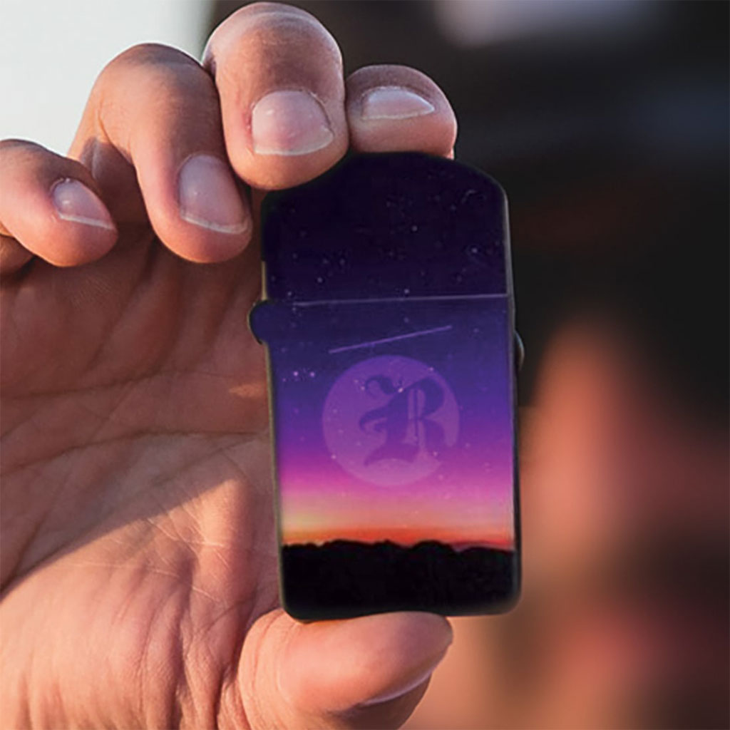 Person holding the Sunset RYOT Verb 510 battery outdoors; a portable, palm-sized vape battery with a flip-top lid for discreet use.