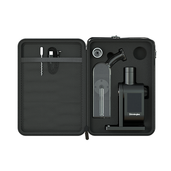 A high-angle studio shot looking inside the open Stündenglass Modül + Dok Deluxe Travel Case with Clear Glass. The image showcases the premium, custom-molded foam interior slots, revealing how the Dok handle, Modül power base, crystal-clear glass globe, magnetic tank sleeves, loading tool, and charging cables are safely organized and securely isolated for high-impact travel protection.