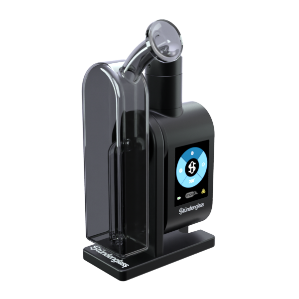 A crisp, front-angle studio product shot of the fully assembled Stündenglass Modül + Dok with Gray Glass. The device is turned slightly to the side to showcase its ergonomic profile, illustrating how the digital Modül battery base sits completely integrated flush within the black anodized Dok station frame beneath the sleek, rounded smoky gray glass filtration globe.