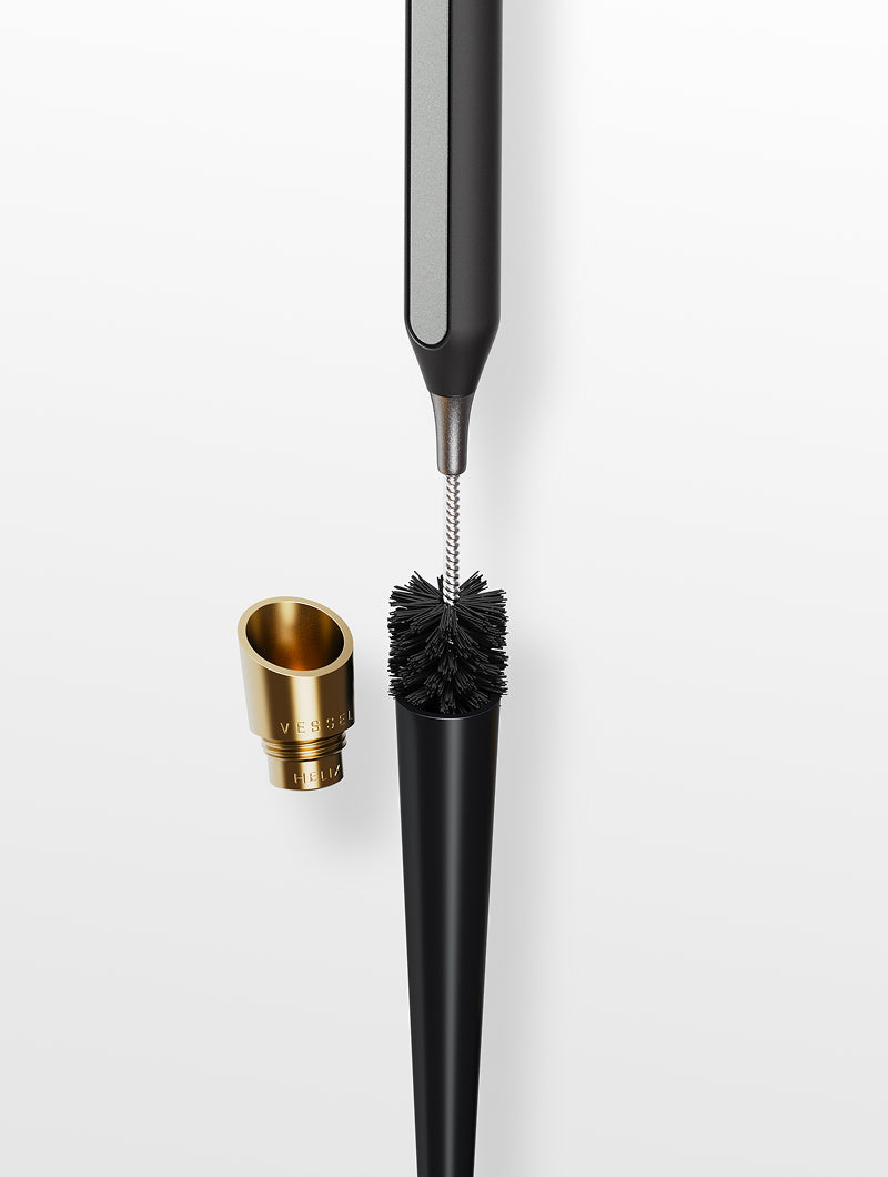 A demonstration showing the Sweeping Brush from the Care Kit being used on a Vessel Cone series pipe. The image highlights how the brush bristles are designed to reach into the tapered interior of the cone to loosen debris and maintain optimal airflow, demonstrating safe and effective maintenance for metal hardware.