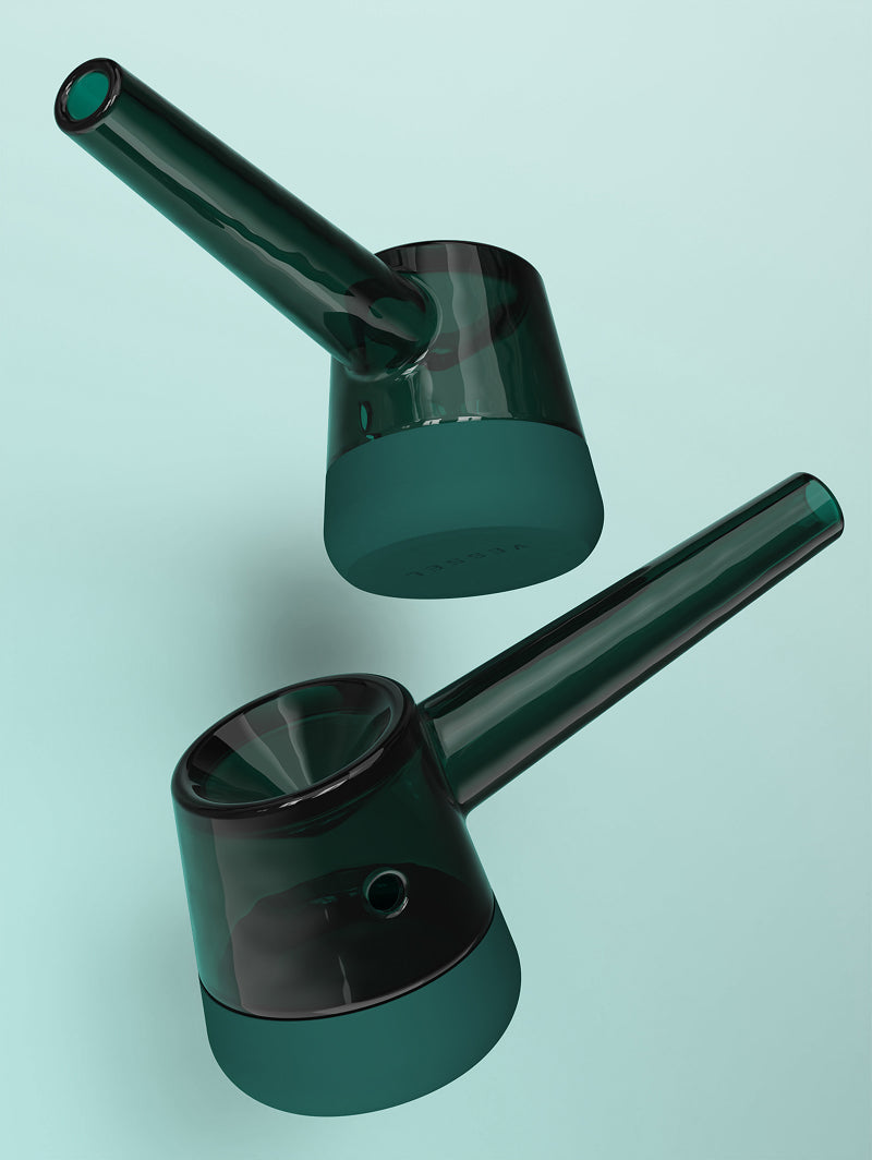 A duo shot of two Vessel Forge Emerald pipes showcasing different side angles. The image highlights the ergonomically sculpted neck and the smooth, frosted texture of the borosilicate glass as it transitions into the vibrant emerald green silicone base.
