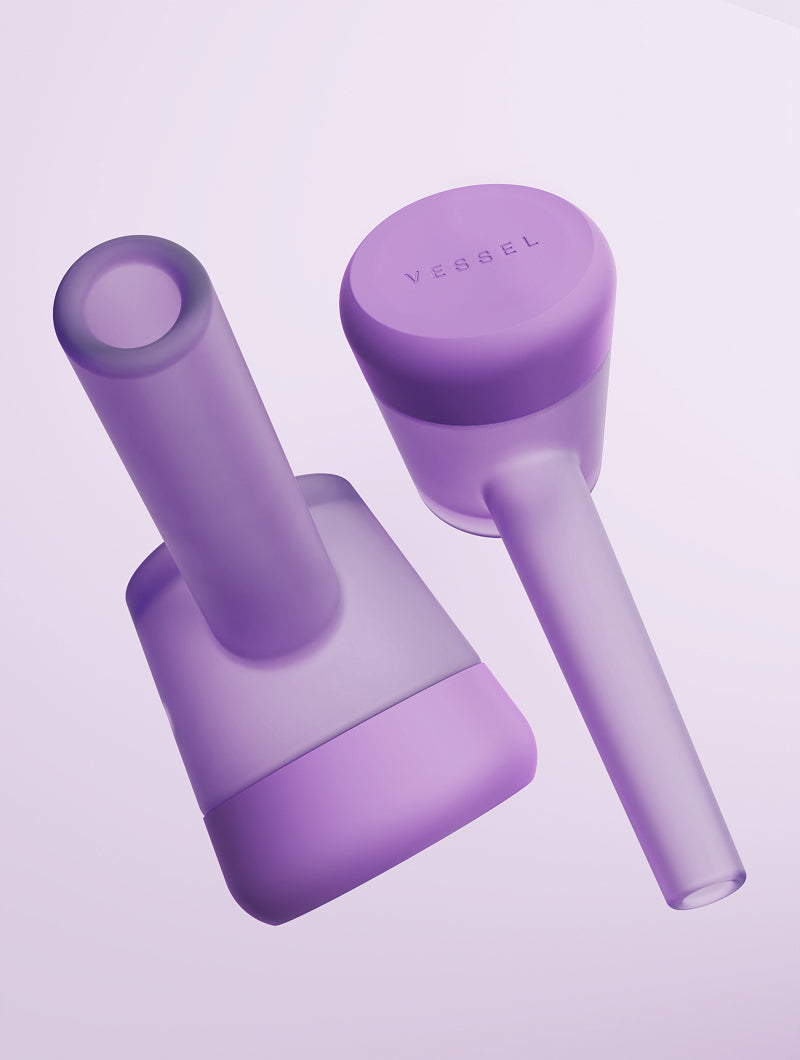 A duo shot of two Vessel Forge Lilac pipes from contrasting angles. One pipe is shown from the rear to highlight the smooth, ergonomic mouthpiece, while the second is inverted to showcase the protective, soft-touch lilac silicone base, emphasizing the pipe's unique balance and surface protection.