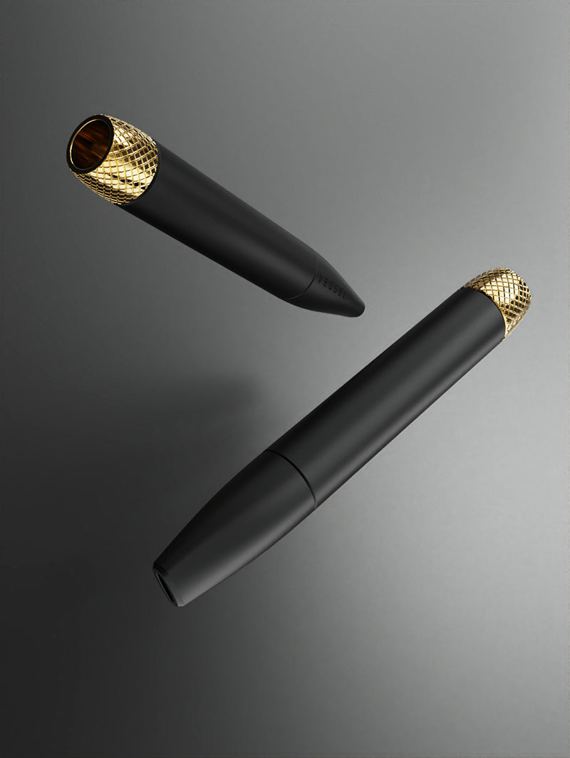 A side-by-side display of two Vessel Helix pipes in Black. One pipe is shown in full profile, while the second is angled to highlight the mouthpiece and the sleek, matte black body. The Vessel logo is clearly visible near the mouthpiece, emphasizing the high-end branding.