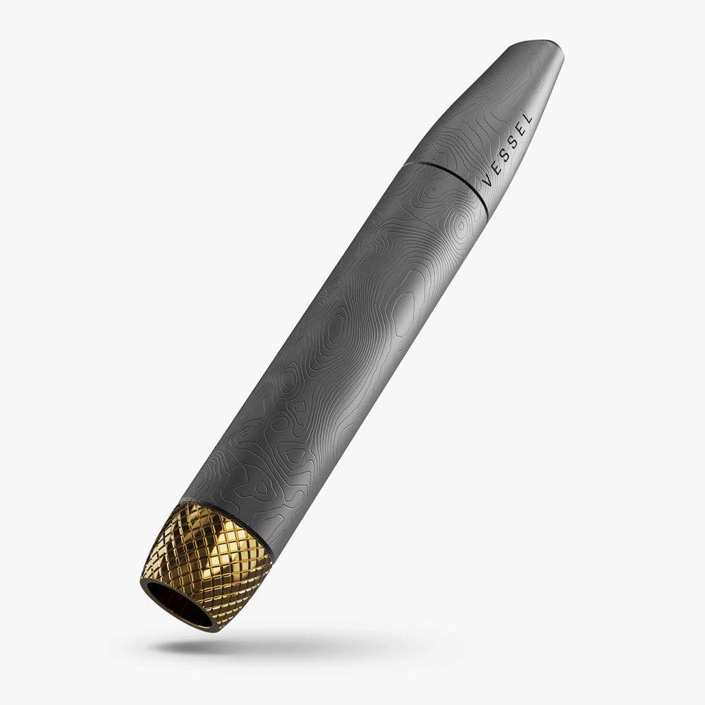 A detailed shot of the Vessel Helix Stone pipe, showcasing the high-quality brass bowl and the sophisticated, architectural design of the exterior. The image emphasizes the premium build quality and ergonomic shape of this luxury one-hitter.