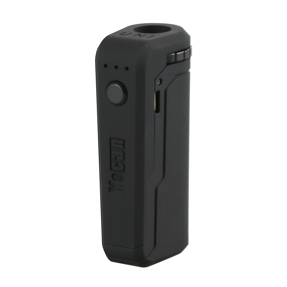 A front-facing studio shot of the Yocan UNI in Black. The device features a sleek, matte black finish with a single circular firing button and three LED indicator lights. This angle highlights the debossed Yocan logo and the side-mounted micro-USB charging port.