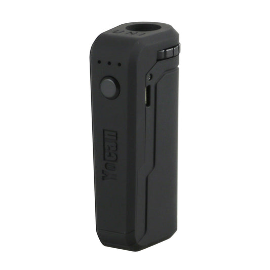 A front-facing studio shot of the Yocan UNI in Black. The device features a sleek, matte black finish with a single circular firing button and three LED indicator lights. This angle highlights the debossed Yocan logo and the side-mounted micro-USB charging port.