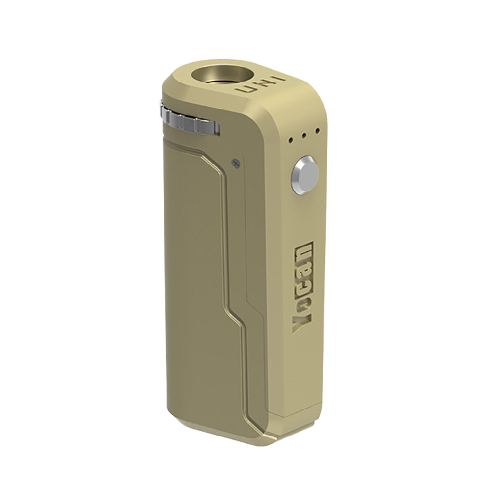 A front-angle studio shot of the Yocan UNI in Matte Gold. The device features a sophisticated, dull-metallic gold finish that covers the entire chassis, paired with a silver firing button and adjustment dial. The three LED indicators are centered above the button, highlighting the classic UNI silhouette.
