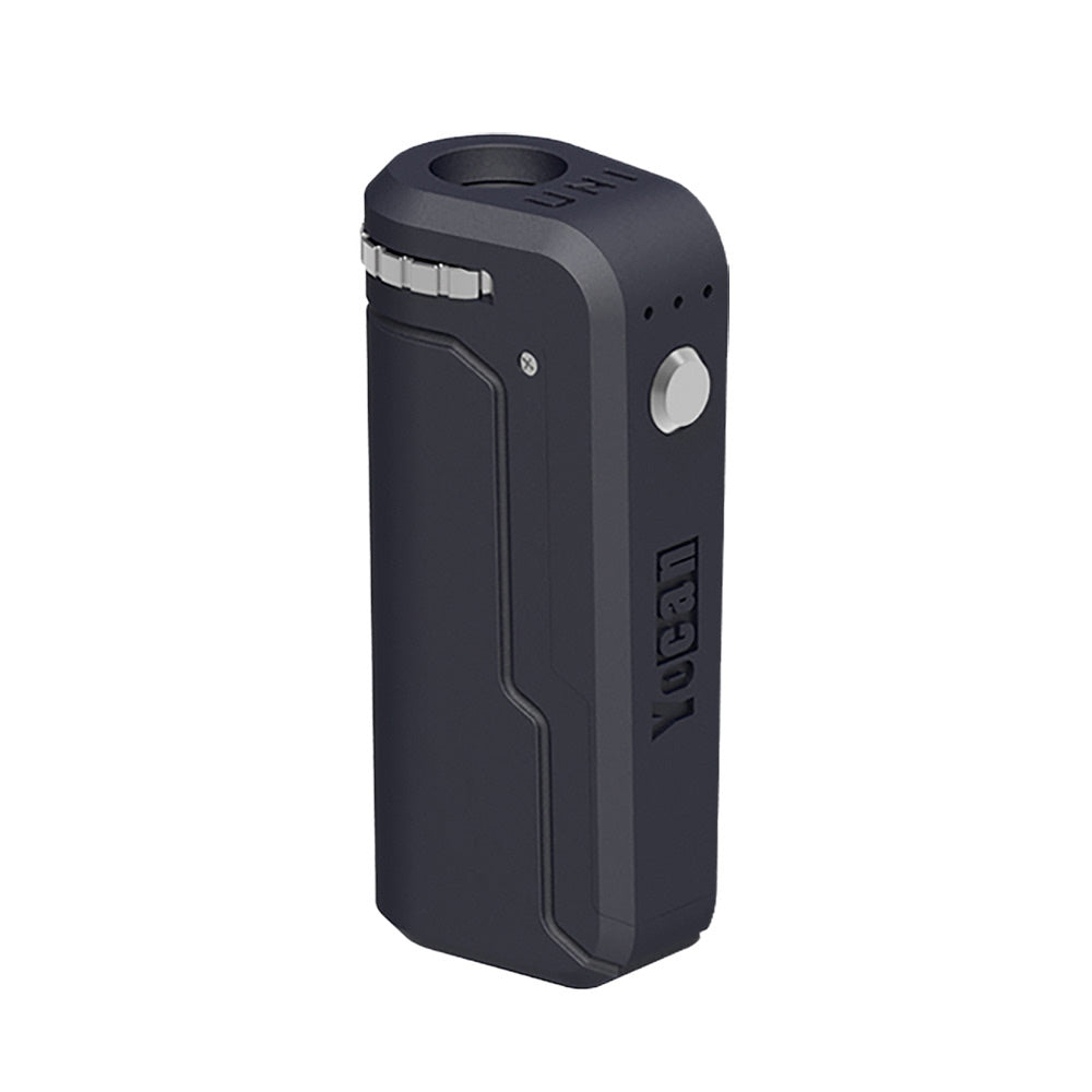 A front-angle studio shot of the Yocan UNI in Smoky Gray. The device features a deep, charcoal-gray matte finish that pairs perfectly with the silver firing button and adjustment dial. The three-light LED indicator is visible above the button, highlighting the device's simplified temperature interface.