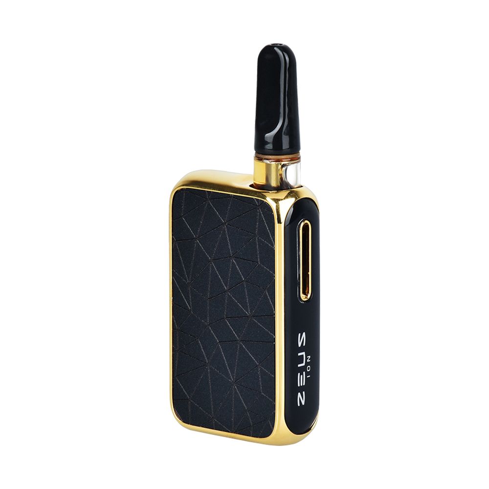 A crisp, front-angle studio profile shot of the Zeus Ion vape battery in Matte Black and Gold. The presentation highlights the device's ergonomic, faceted geometric edges and gold structural accents, showing a universal 510 oil cartridge dropping perfectly into the integrated magnetic concealed port.
