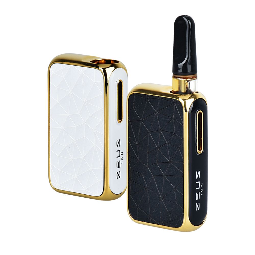 A clean studio product shot showcasing two colorways of the Zeus Ion 510 vape battery side-by-side. The image displays the luxurious geometric, angled bodies in premium White with Gold accents and Matte Black with Gold accents. The Black/Gold model is shown on the right with a clear 510-threaded oil cartridge installed inside the concealed base chamber, leaving only the glass mouthpiece visible at the top.